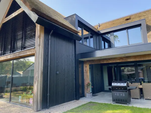 Thermisch gemodificeerd hout met zwarte beits toegepast als gevelbekleding in barcode profiel.