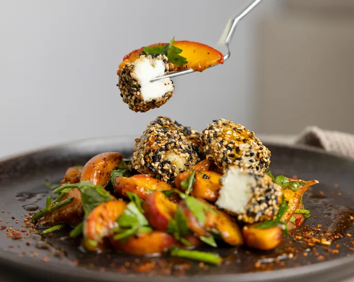 Halloumi-Sesam-Bites auf gegrilltem Pfirsichsalat / mit Chiliöl-Honig
