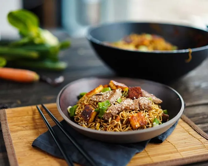 Gemüsenudelpfanne im Wok mit Rinderstreifen und Käse