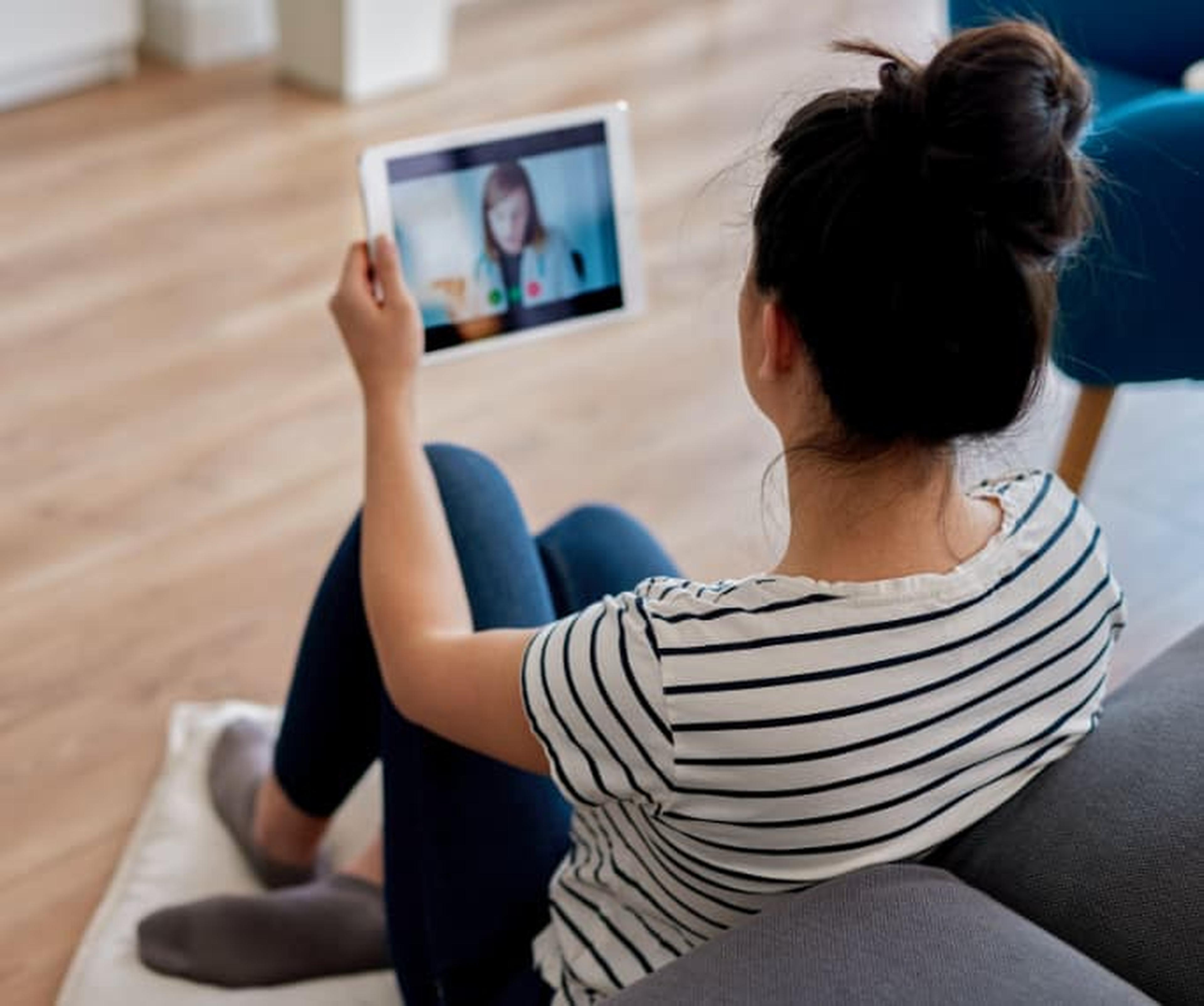 woman looking at video call on tablet