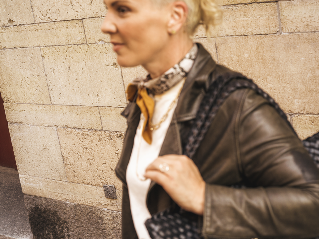 Kvinna med skinnjacka och scarf