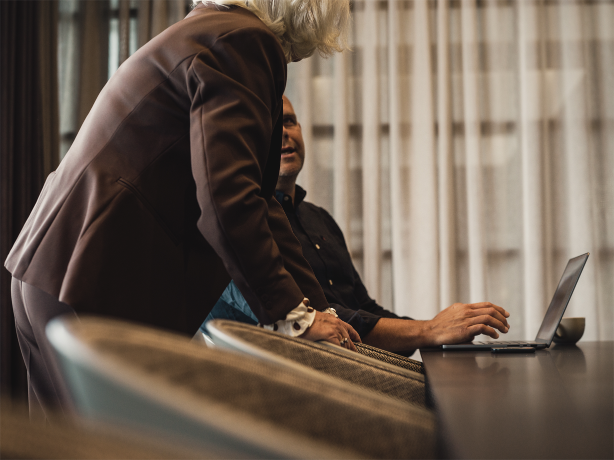 Man och kvinna pratar framför dator