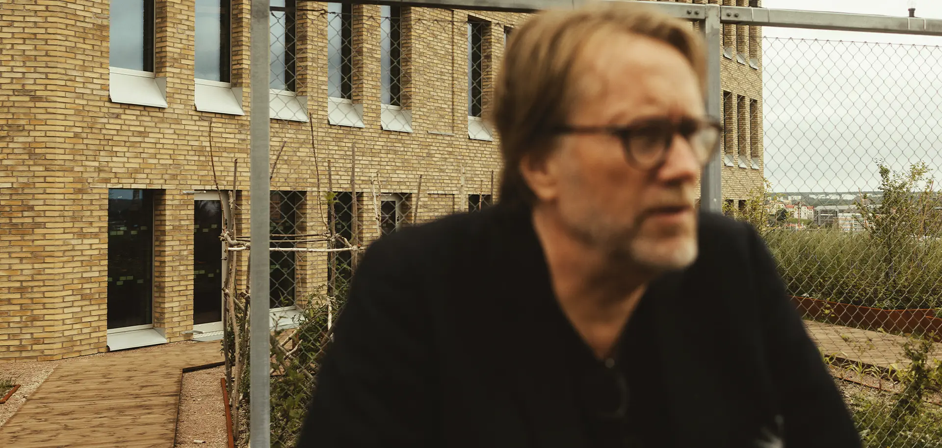 Man som står framför ett lägenhetshus