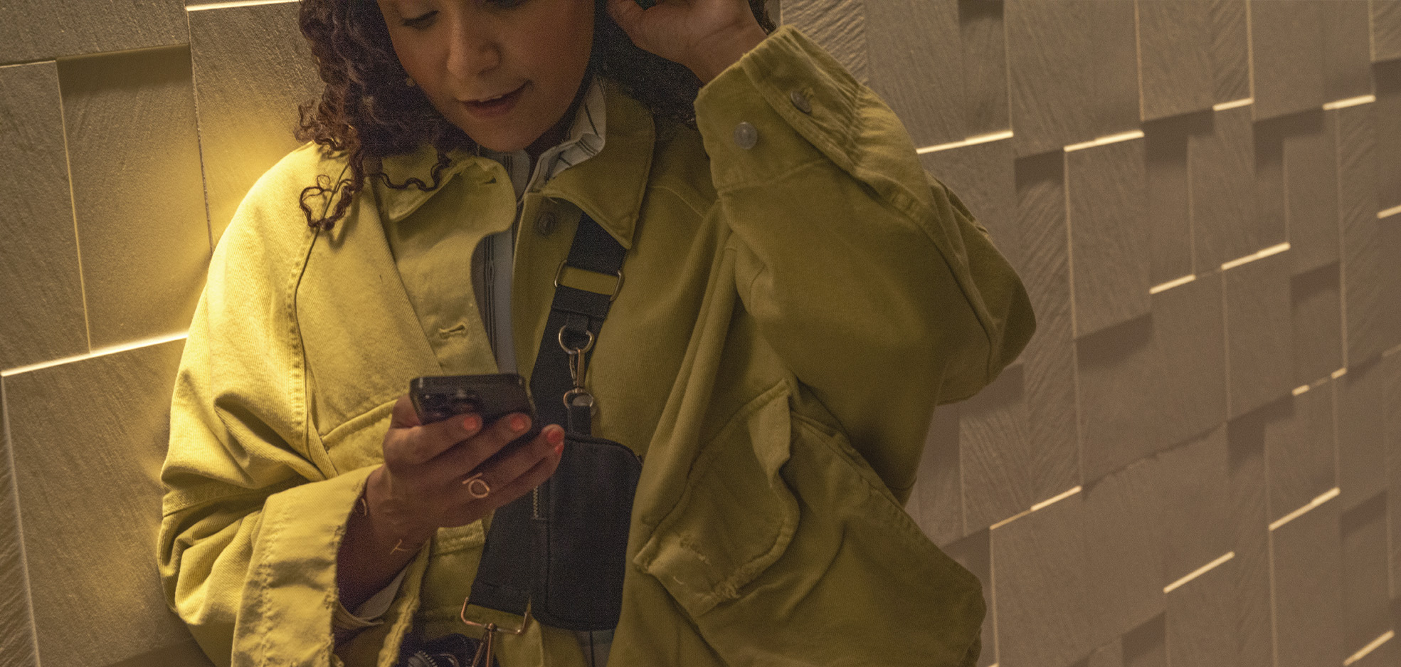 Kvinna står och kollar i telefon