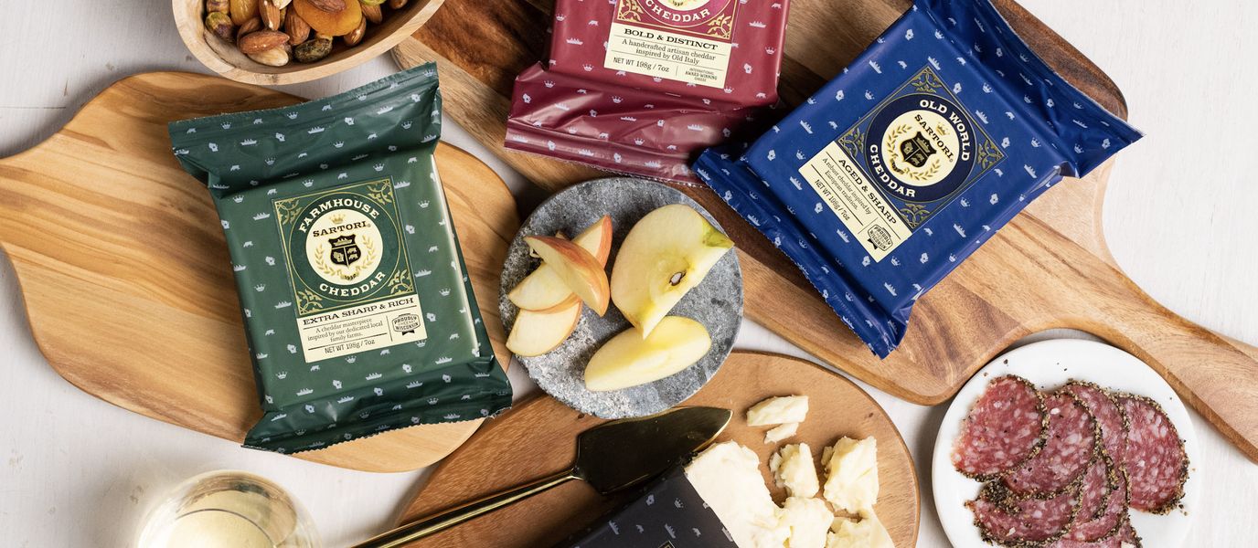 Variety of Sartori Cheddar blocks with food and drink pairings.