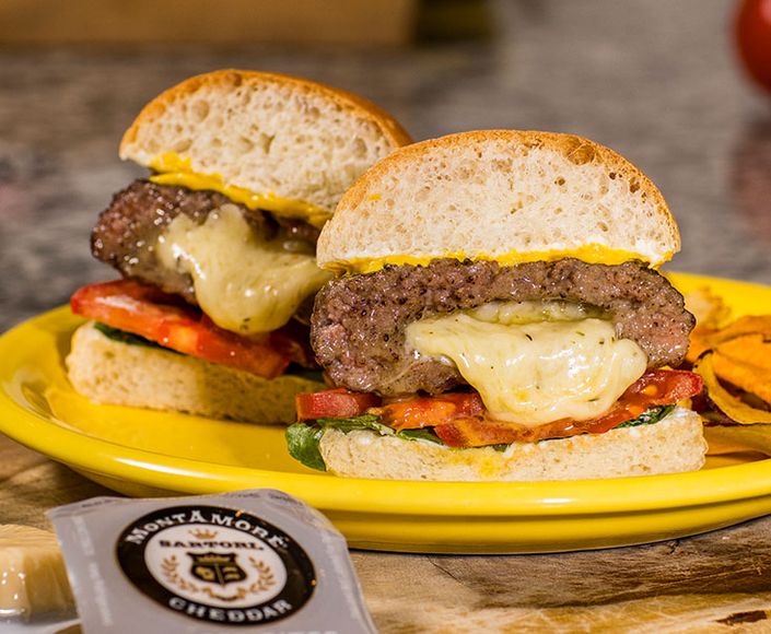 Two Jucy Lucy cheeseburgers with melting Montamore Cheddar Cheese Bites