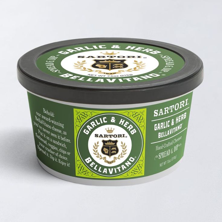 A tub of Sartori Garlic & Herb Bellavitano cheese spread, featuring a green label with the brand's logo and decorative design.