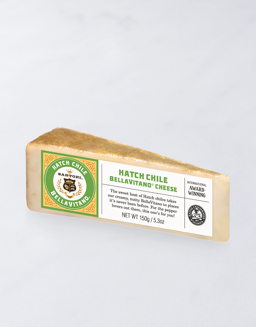 Triangle wedge of Hatch Chile BellaVitano cheese with label detailing award-winning status, weight of 150g, and the Sartori logo.