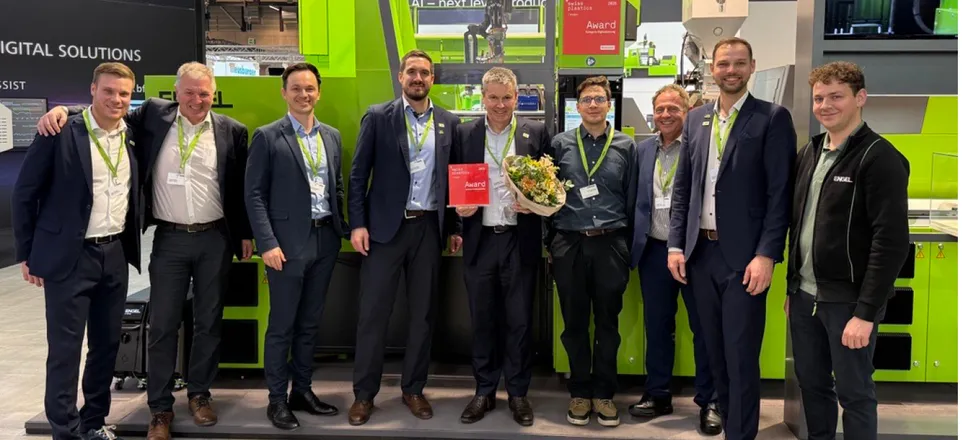Bild zeigt eine Gruppe von ENGEL Mitarbeitern vor der ersten autonomen Spritzgießzelle auf der Swiss Plastics Expo