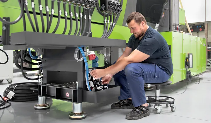 Picture shows service technician during machine maintenance by ENGEL