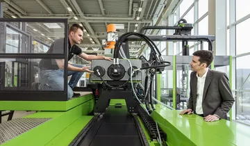 Picture shows service technician and customer at an ENGEL injection moulding machine
