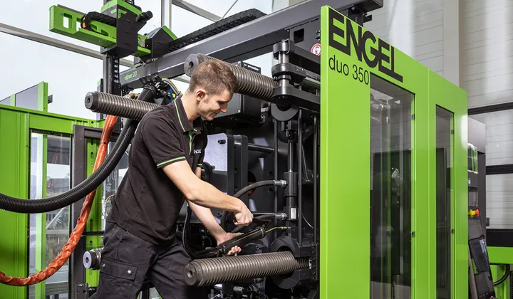 Photo montrant un technicien de service dans une presse à injecter d'ENGEL