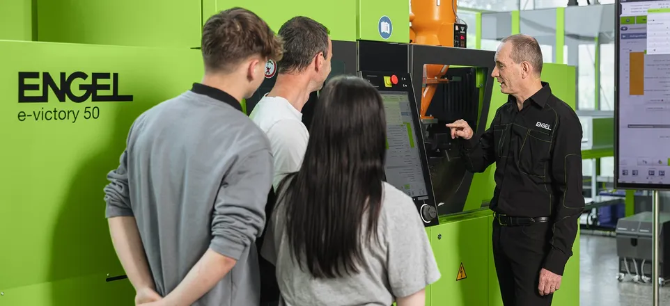 Picture shows trainer and participants in front of ENGEL machine