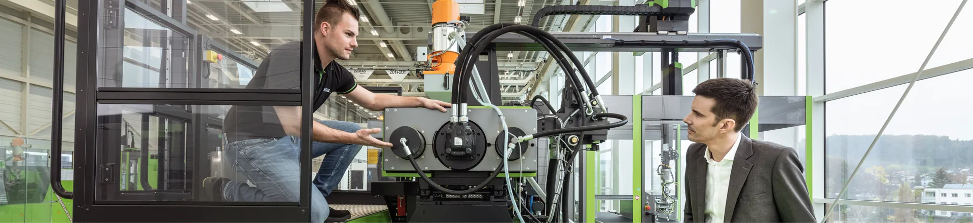 Picture shows service technician and customer at an ENGEL injection moulding machine