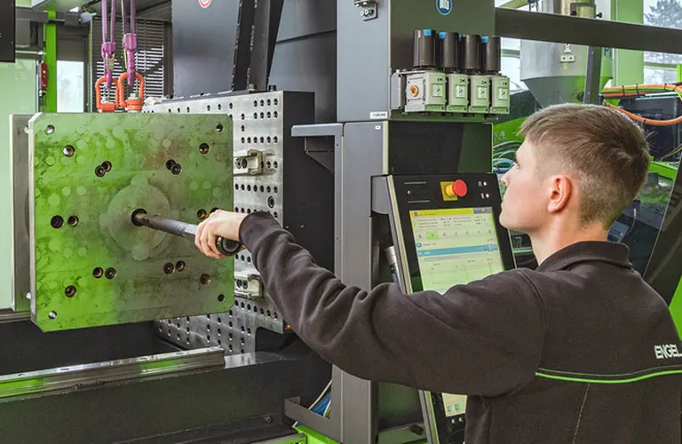 Bild zeigt Maschineneinrichter bei der Anwendung des menügeführten Rüstassistenten zur Rüstzeitoptimierung im Spritzguss