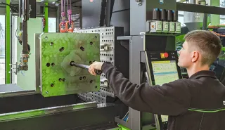 Bild zeigt Maschineneinrichter bei der Anwendung des menügeführten Rüstassistenten zur Rüstzeitoptimierung im Spritzguss