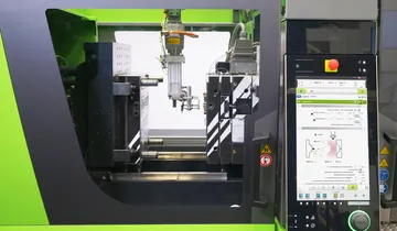 Picture shows smart robot in the mould area of an injection moulding machine
