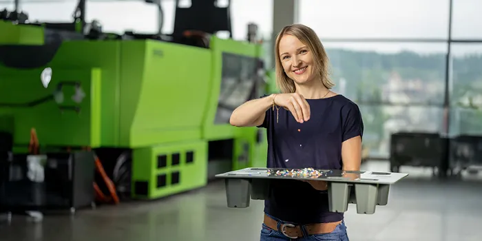 Bild zeigt Person mit Kunststoffrezyklaten in der Hand
