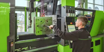 Picture shows machine setter using the menu-guided set-up assistant to optimise set-up times in injection moulding