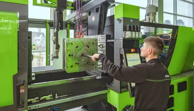 Picture shows machine setter using the menu-guided set-up assistant to optimise set-up times in injection moulding