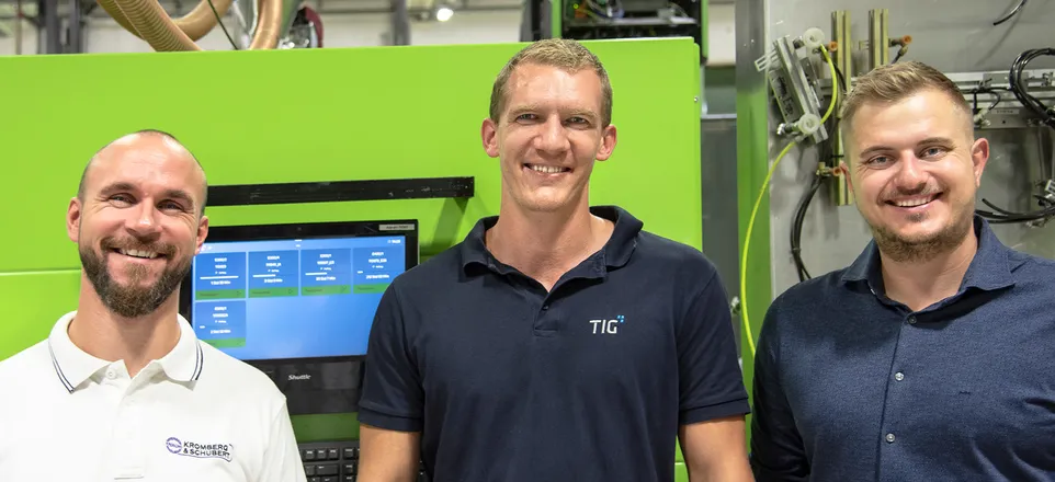 Na snímku Robert Jautz ze společnosti KROSCHU, Alexander Ebner a David Kupfer ze společnosti ENGEL před zeleným vstřikovacím strojem ENGEL a terminálem.