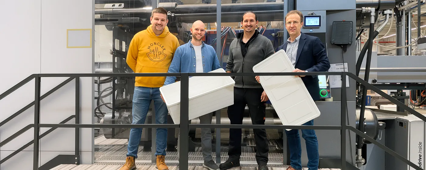 Bild zeigt Mitarbeiter von SLG und ENGEL vor einer duo 2-Platten-Spritzgießmaschine