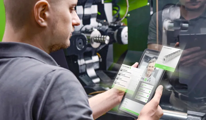 Picture shows service technician in front of an ENGEL injection moulding machine