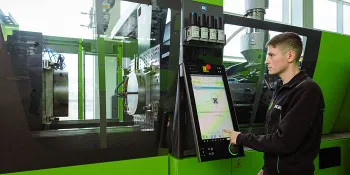 Picture shows a machine operator setting up an ENGEL injection moulding machine