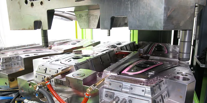 Picture shows overmoulding of inserts in a vertical injection moulding machine