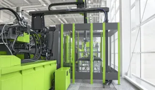 ENGEL injection molding machine beside an enclosed automation cell