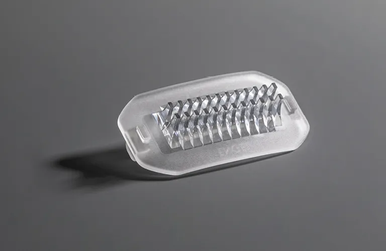 La imagen muestra componentes de plástico transparentes producidos mediante moldeo por inyección de silicona