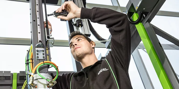 На фото показана замена запчасти на роботе ENGEL