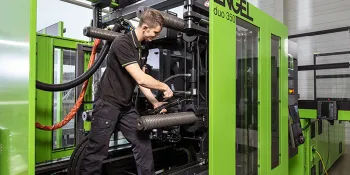 Picture shows service technician in an injection moulding machine