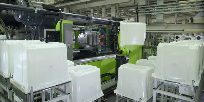 La imagen muestra el piso de producción con máquinas de moldeo por inyección ENGEL