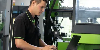 Picture shows service technician in front of networked injection moulding machine