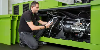 Picture shows service technician in front of ENGEL injection moulding machine