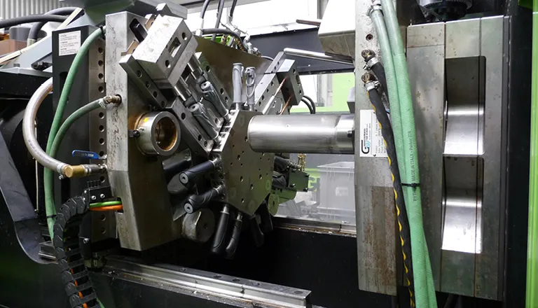 Picture shows tie-bar-less injection moulding machine in production