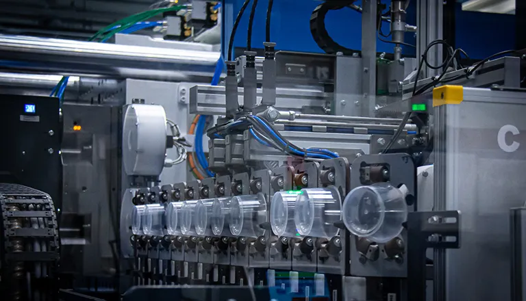 Picture shows production of a plastic yoghurt pot