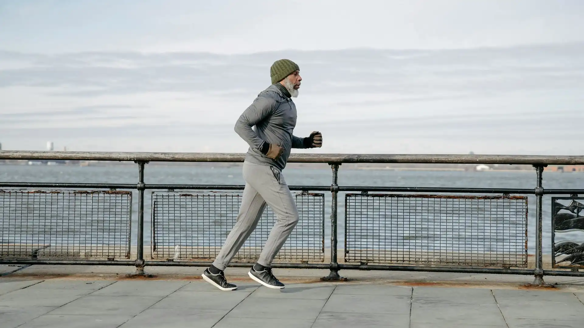 An elderly man running beside the beach