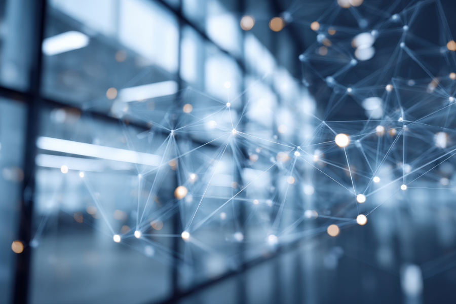 Abstract image of interconnected glowing nodes and lines in a blurred blue and gray environment, resembling a network or digital web.