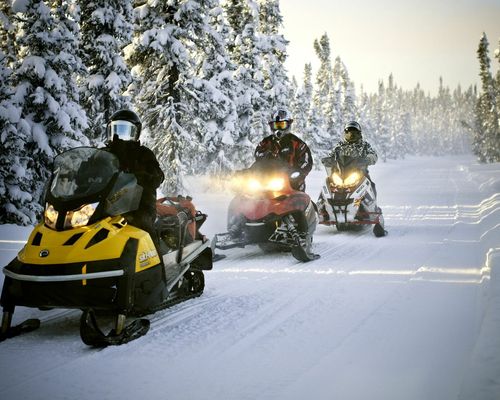 group of people snowmobiling together in the snow