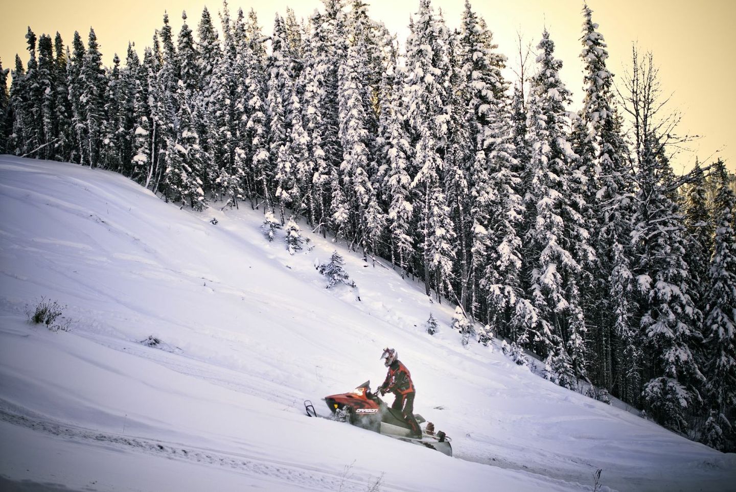 snowmobiling up a mountain hill