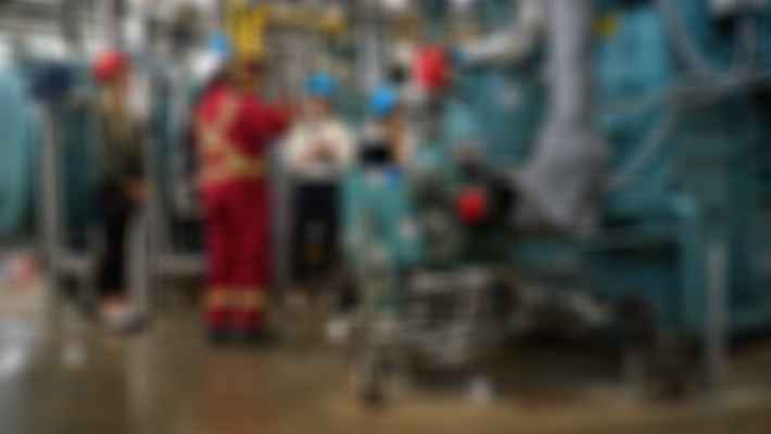 workers discussing in oil sands facility