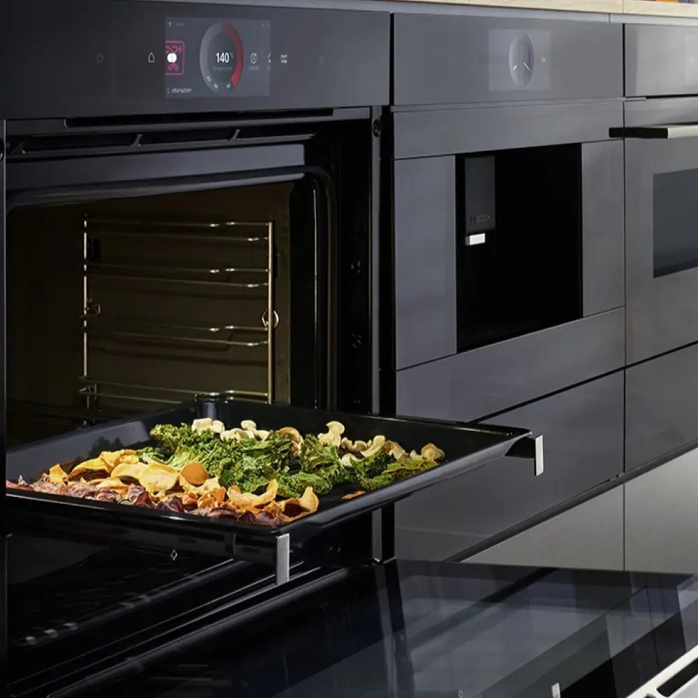 Geöffneter Backofen. Darin ein Backbleck mit gegrilltem Gemüse.