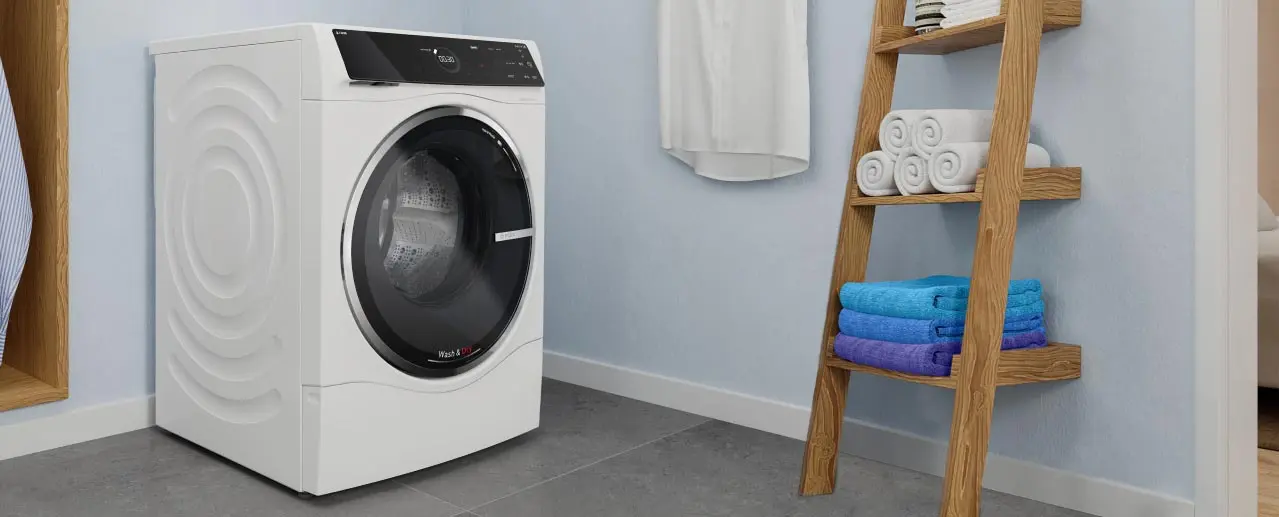 Was-droogcombinatie van Bosch, naast een houten rek met opgevouwen handdoeken.