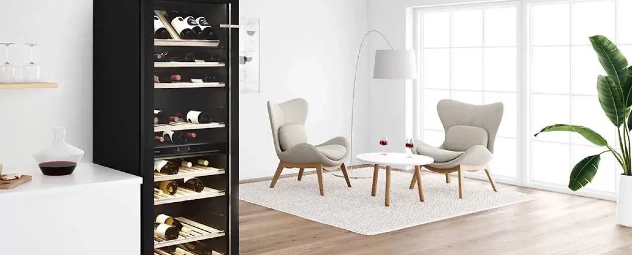 Vrijstaande Bosch wijnklimaatkast met flessen rode en witte wijn in een huiskamer.