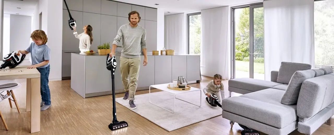 Bosch cordless stick vacuum cleaner used in various ways in the kitchen and living room.