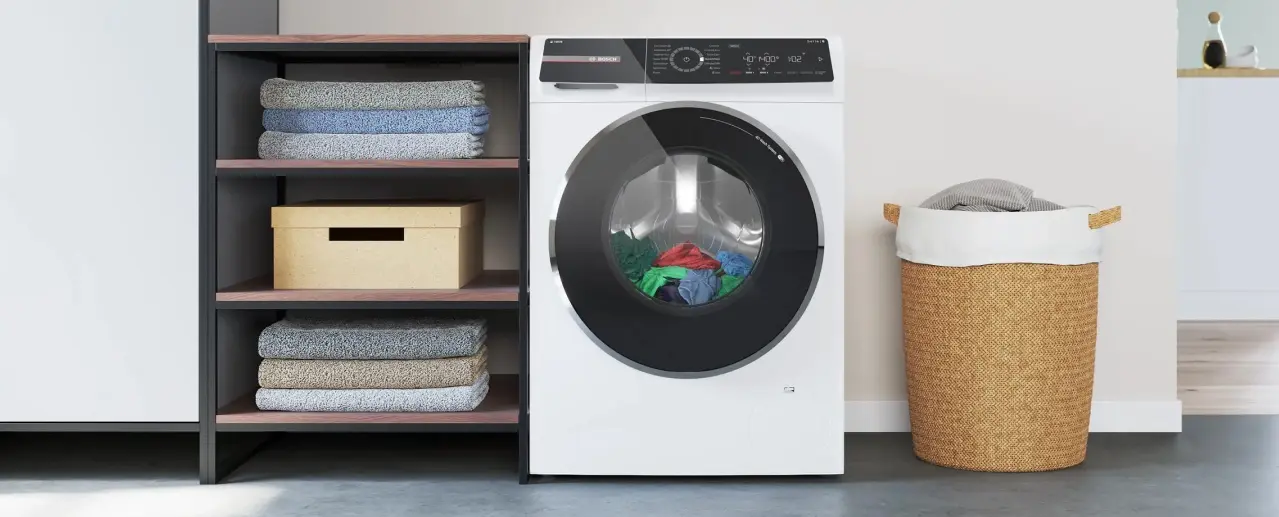 Witte Bosch wasmachine met wasgoed erin.