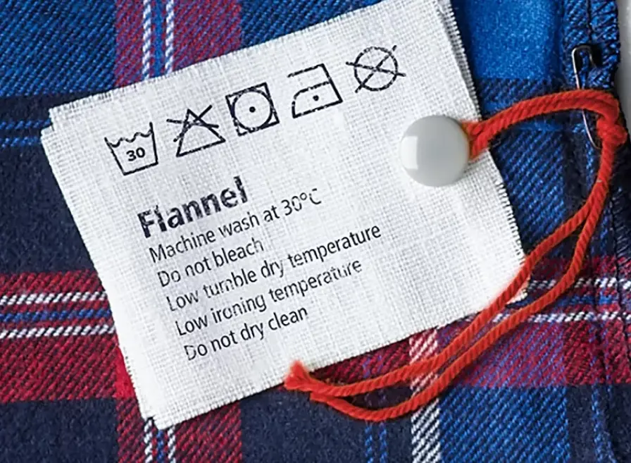 Waslabel met wassymbolen en wasinstructies.