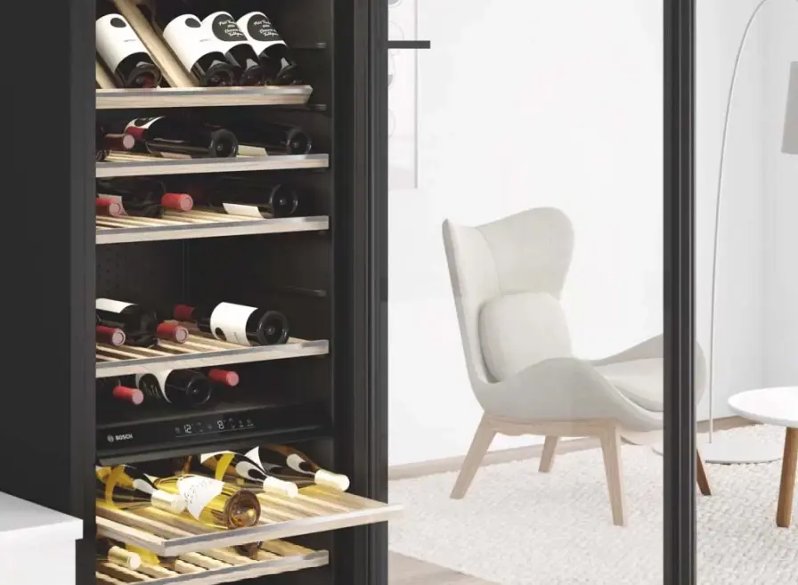 Vrijstaande Bosch wijnklimaatkast met flessen rode en witte wijn in een huiskamer.
